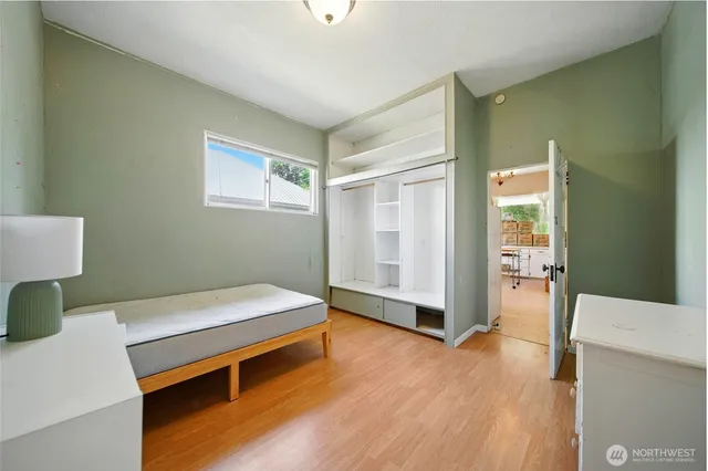 a bedroom with a bed and wooden floor