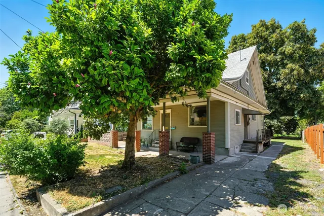 a view of a house with backyard and a tree