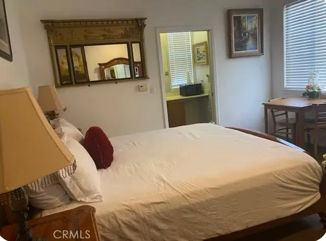 a bedroom with a bed and dresser with mirror