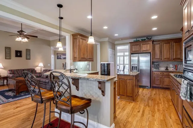a living room with furniture a fireplace and a ceiling fan