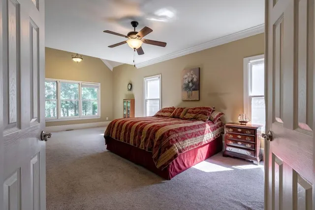 a bedroom with a large bed a flat tv screen and dresser