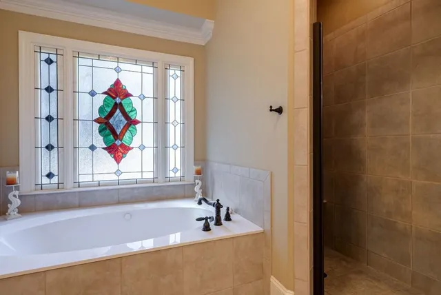 a spacious bedroom with a bed a couch and a chandelier