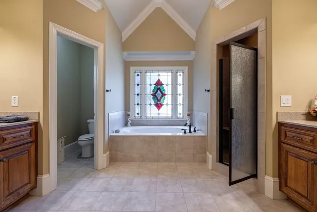 a spacious bedroom with a bed a couch and a chandelier