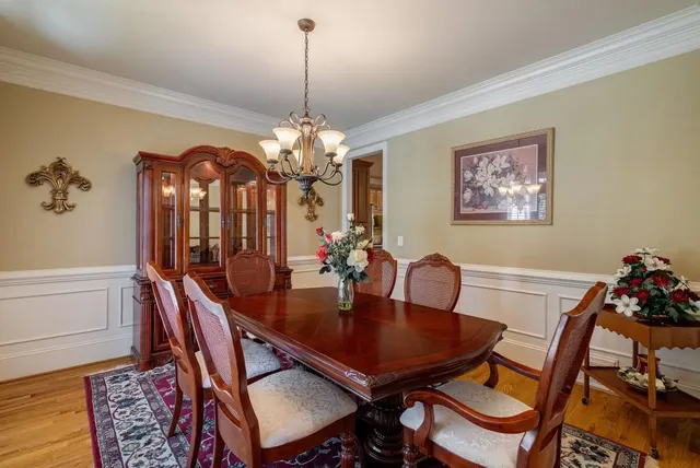 a dining room with furniture a chandelier and wooden floor