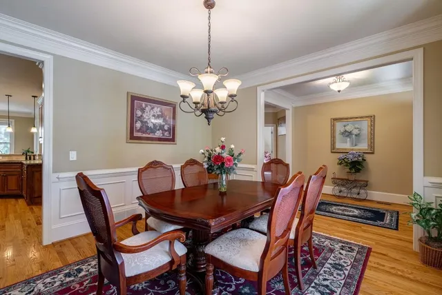 a kitchen with stainless steel appliances granite countertop wooden cabinets a sink a stove a refrigerator and island with wooden floor