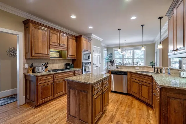 a view of a dining room and livingroom with furniture wooden floor a chandelier