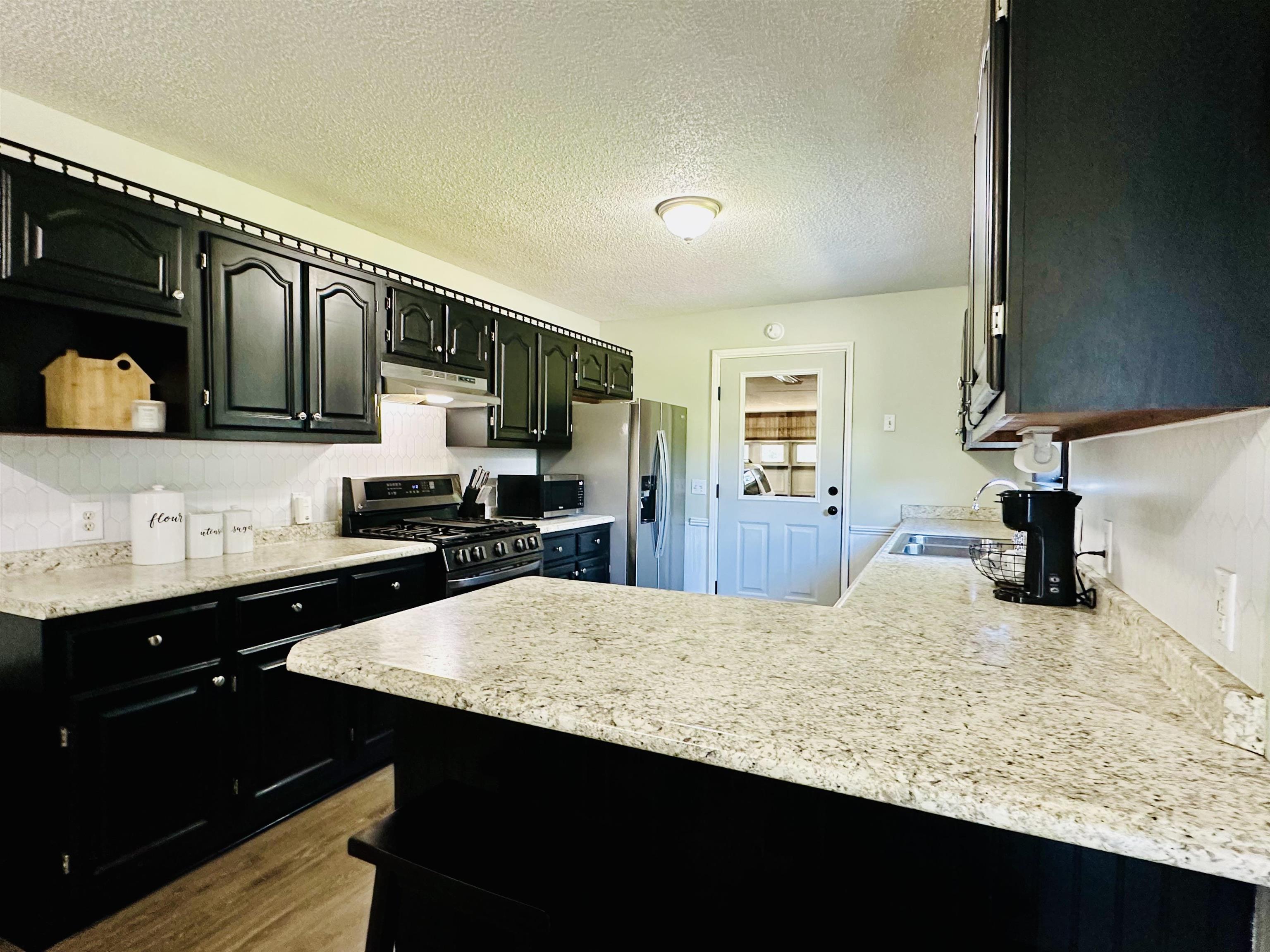 7120 Powell Chapel Road Hornsby, TN 38044 - Photo 5 of 29 a kitchen with a sink a stove and cabinets