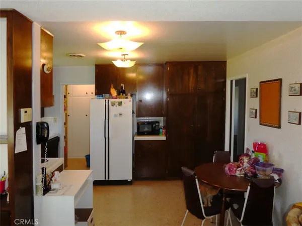 a view of kitchen with furniture and a refrigerator