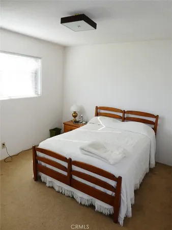 a bed sitting in a bedroom next to a window