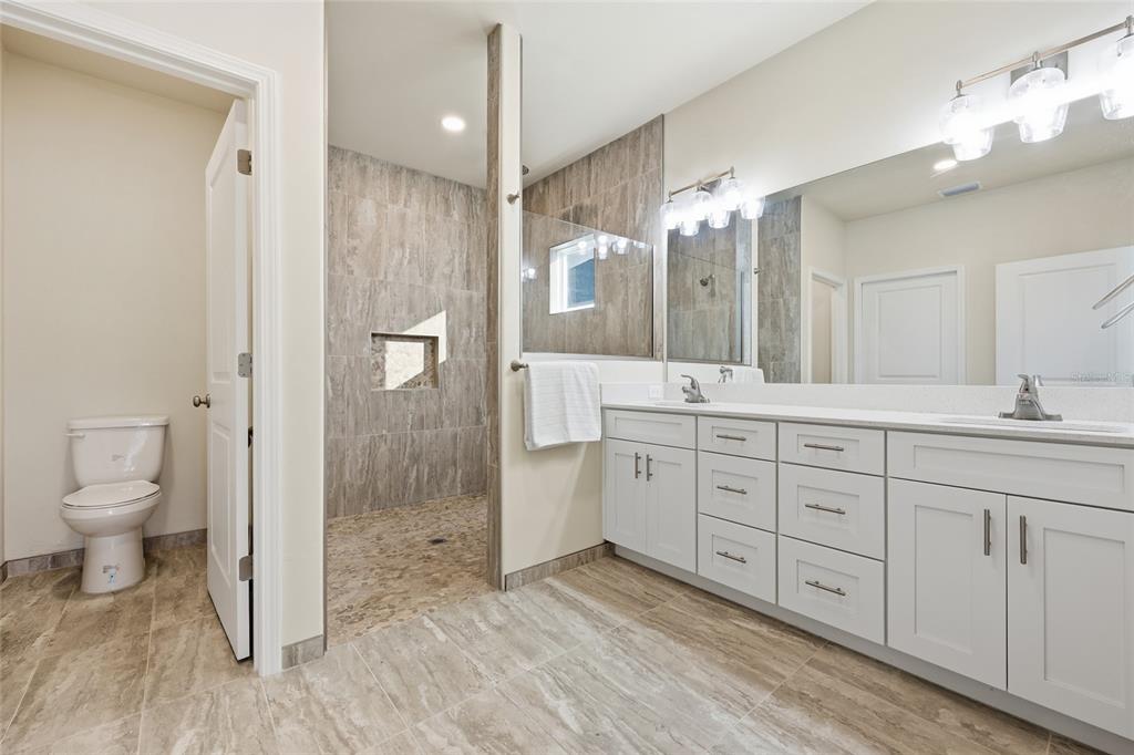 1402 Southwest 67th Drive Gainesville, FL 32607 - Photo 12 of 30 a spacious bathroom with a granite countertop sink a toilet and a shower