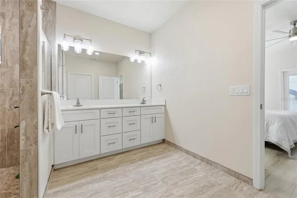 a spacious bathroom with a double vanity sink a mirror and a shower