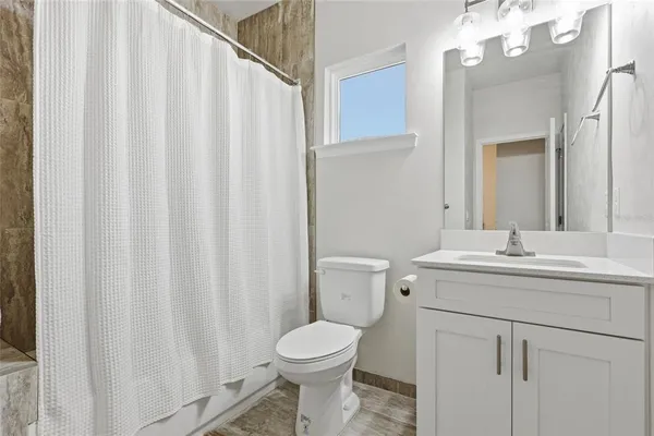 a bathroom with a sink a toilet and shower curtain