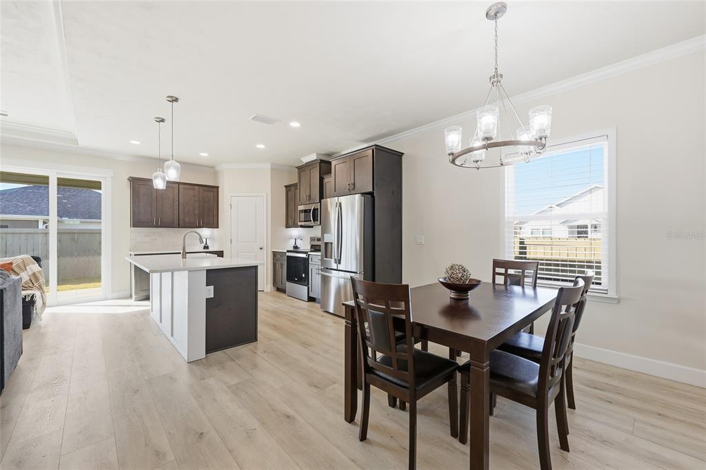1402 Southwest 67th Drive Gainesville, FL 32607 - Photo 2 of 30 a view of a dining room and livingroom with furniture wooden floor a chandelier