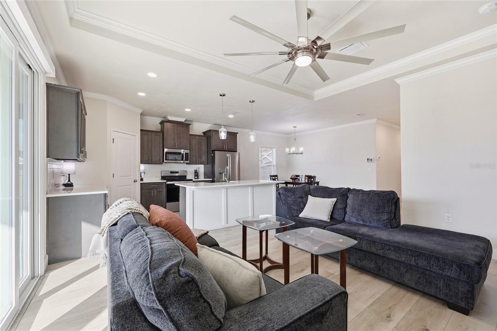 1402 Southwest 67th Drive Gainesville, FL 32607 - Photo 6 of 30 a living room with furniture kitchen view and a chandelier