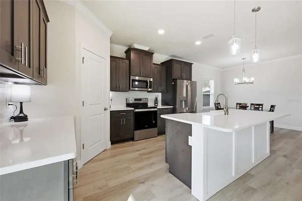 a kitchen with kitchen island a sink stainless steel appliances and cabinets