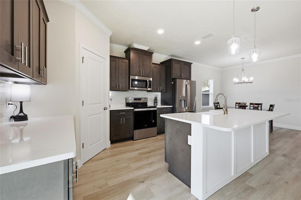 1402 Southwest 67th Drive Gainesville, FL 32607 - Photo 7 of 30 a kitchen with kitchen island a sink stainless steel appliances and cabinets