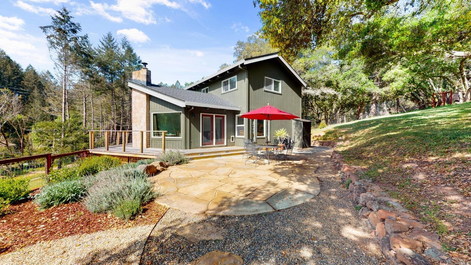 a view of a house with backyard and sitting area
