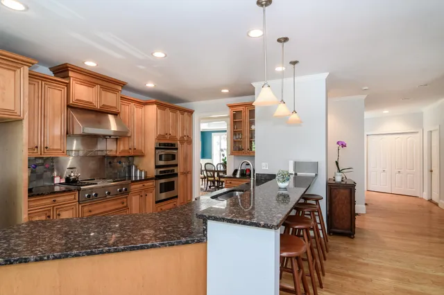 a kitchen with stainless steel appliances granite countertop a sink refrigerator and cabinets