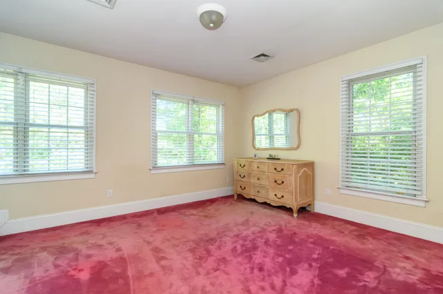 a view of an empty room with a fireplace and a window