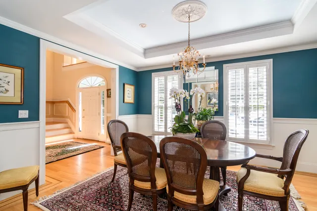 a dining room with furniture a chandelier and wooden floor