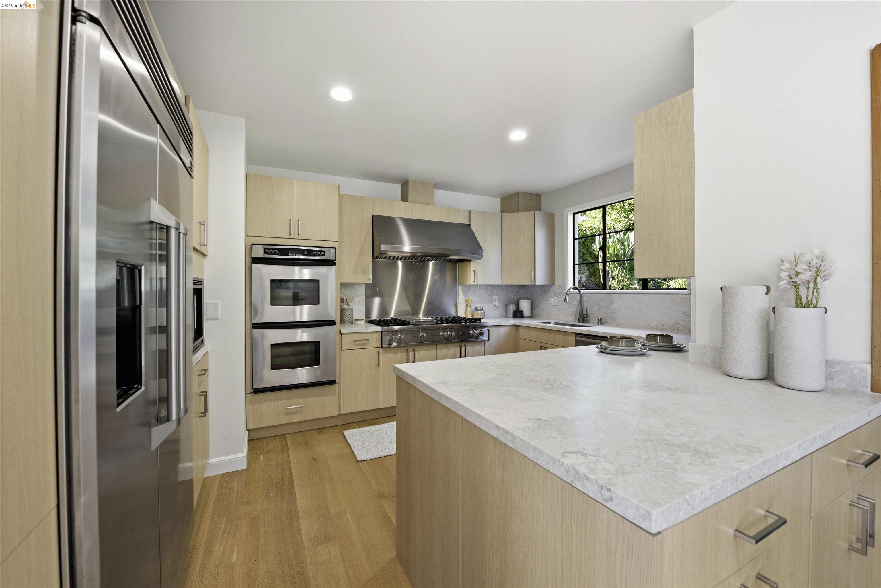 44 Highgate Road Kensington, CA 94707 - Photo 16 of 83 a large kitchen with stainless steel appliances granite countertop a refrigerator a sink dishwasher a oven with white cabinets and wooden floor
