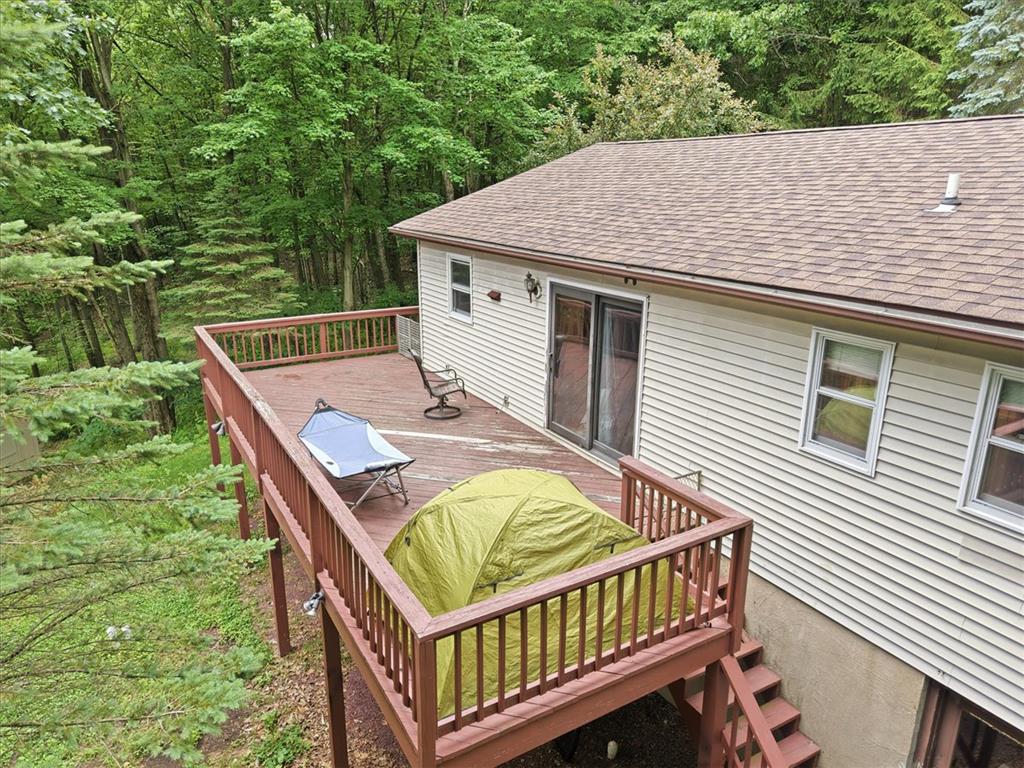 520 Highland Hill Road Jim Thorpe, PA 18235 - Photo 53 of 83 A spacious wooden deck extends into a verdant forest, offering a serene outdoor retreat.