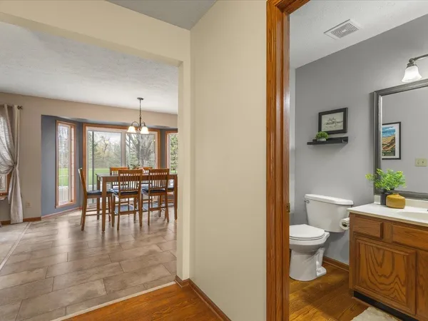 a bathroom with a granite countertop toilet a sink and mirror