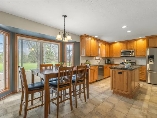a kitchen with granite countertop a stove top oven a sink dishwasher a refrigerator and cabinets with wooden floor