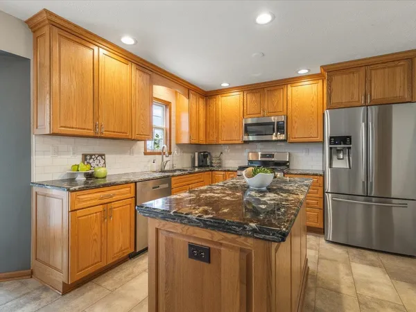 a kitchen with stainless steel appliances granite countertop a stove sink and cabinets