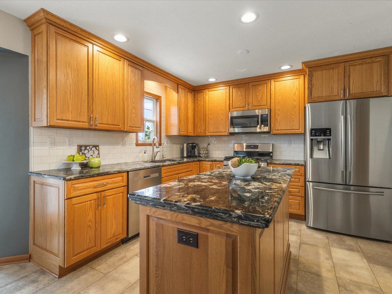 8027 Barclay Road Rockford, IL 61102 - Photo 19 of 67 a kitchen with granite countertop a stove top oven a sink dishwasher a refrigerator and cabinets with wooden floor