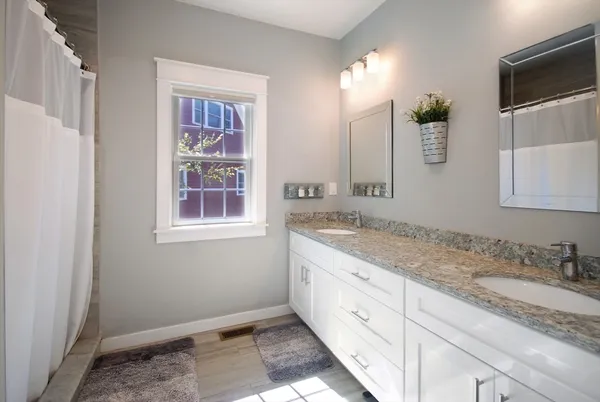 a spacious bathroom with a granite countertop sink and a mirror