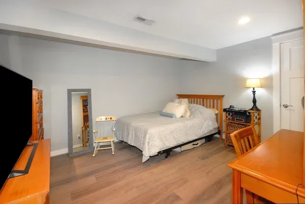 a bedroom with a bed and wooden floor