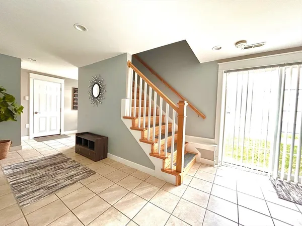 a view of an entryway with wooden floor and a rug