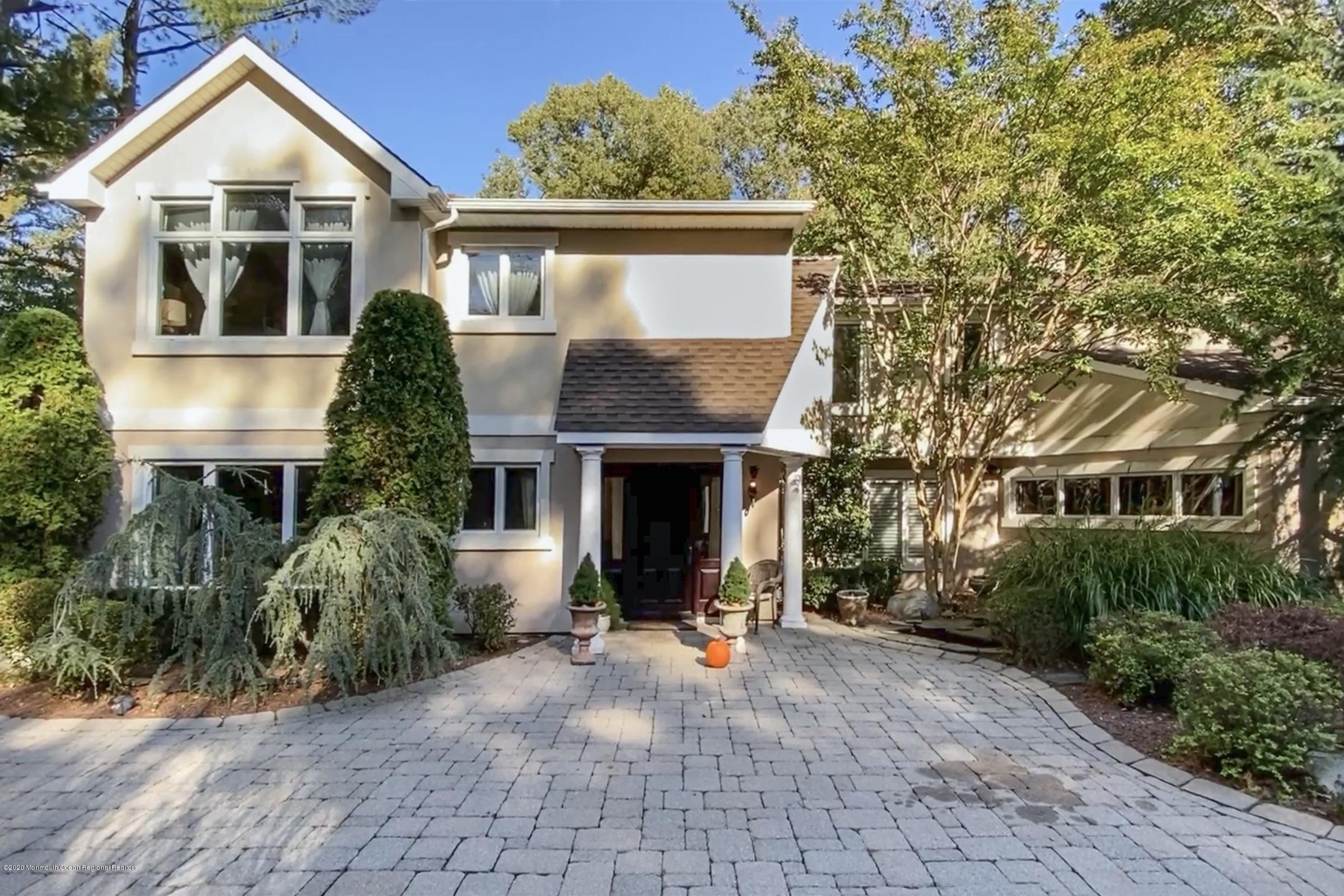 a front view of a house with a yard and trees