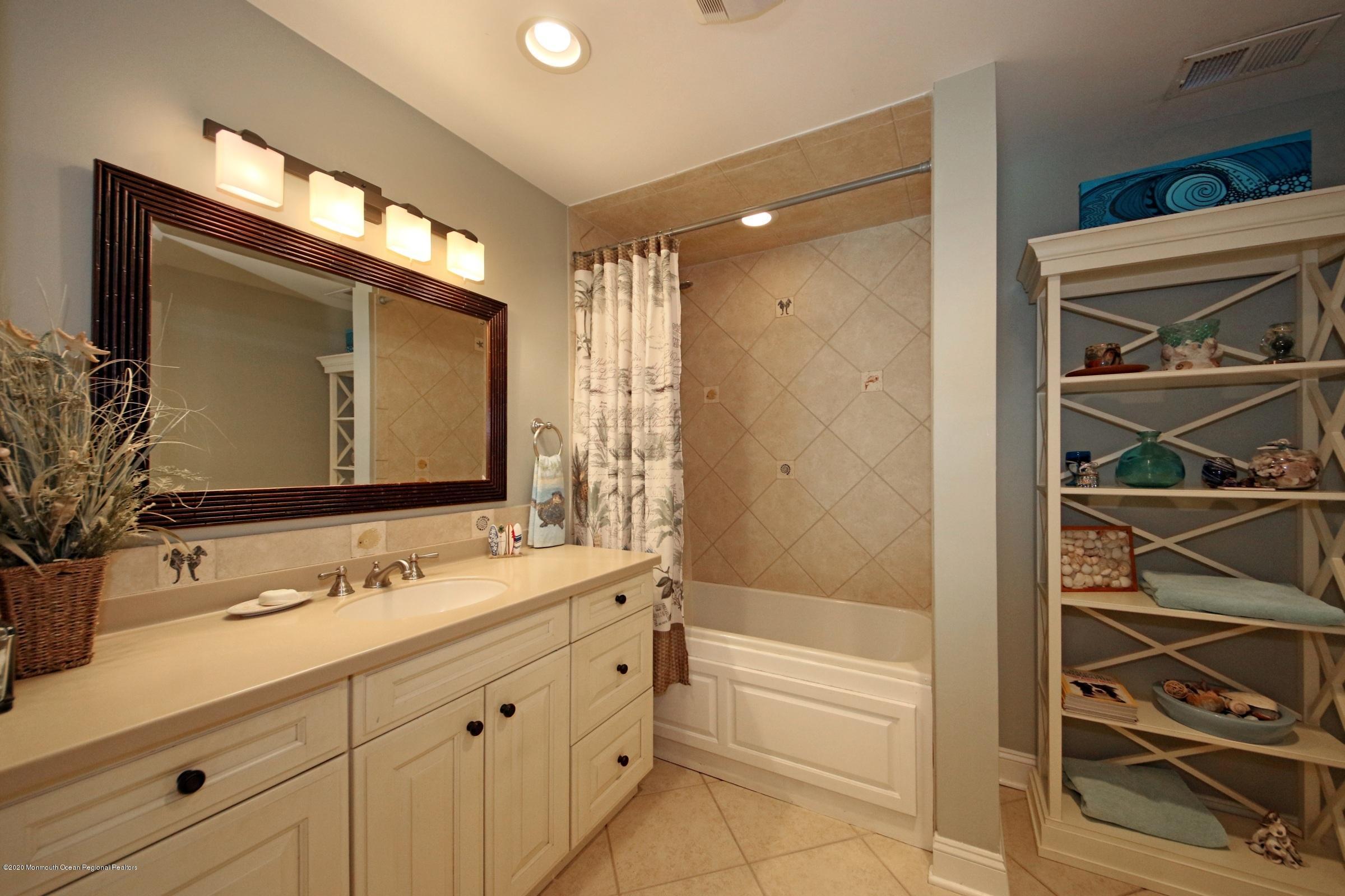 18 Daniel Drive Little Silver, NJ 07739 - Photo 39 of 55 a bathroom with a double vanity sink a mirror and a bathtub