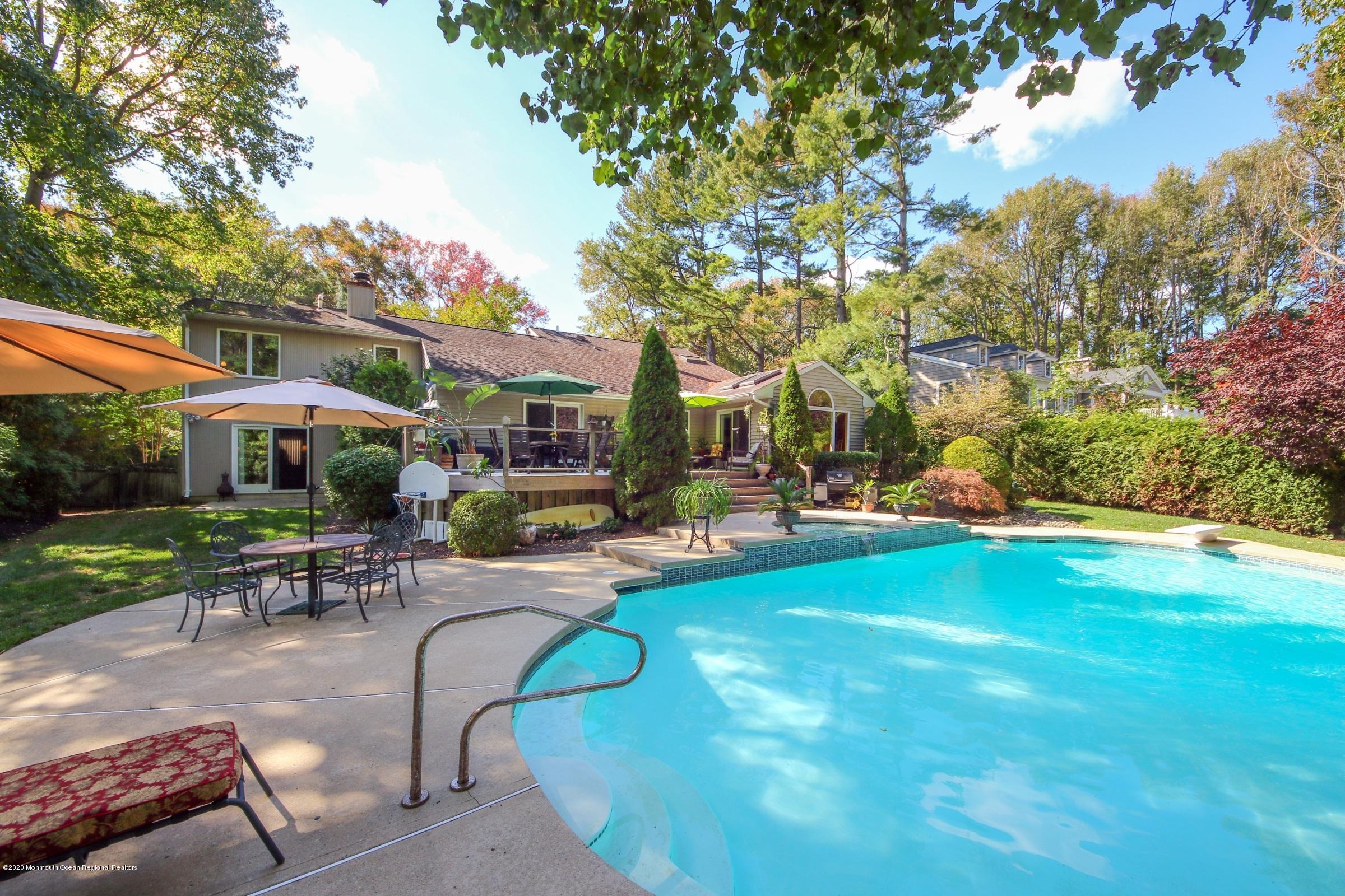 18 Daniel Drive Little Silver, NJ 07739 - Photo 44 of 55 a view of a swimming pool with a table and chairs under an umbrella