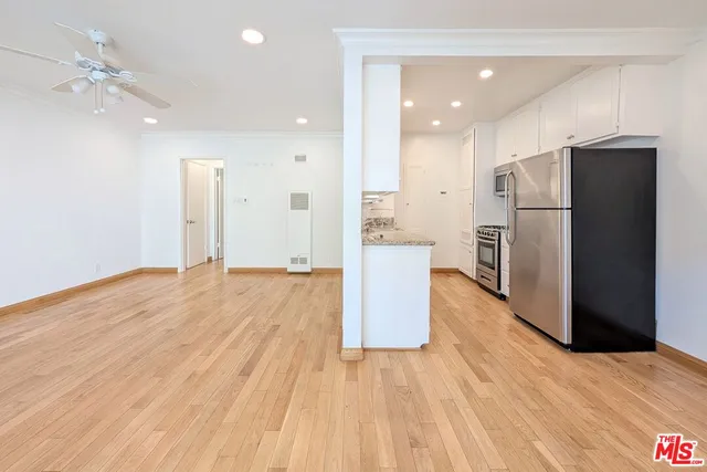 a kitchen with stainless steel appliances a refrigerator and wooden floor
