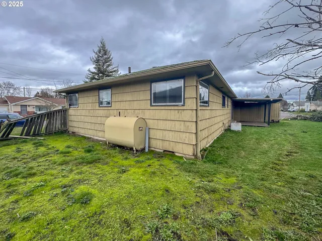 a white house that has a tree in front of it