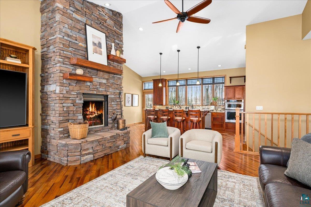 92598 Spells Road Sturgeon Lake, MN 55783 - Photo 8 of 60 Living room with a fireplace, wood finished floors, a ceiling fan, and lofted ceiling