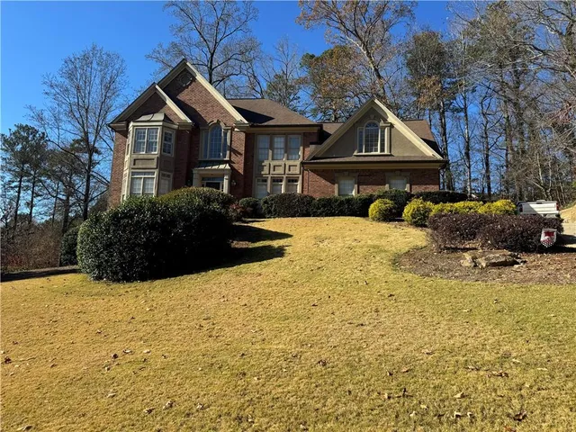 a front view of a house with a yard covered with snow in front of house