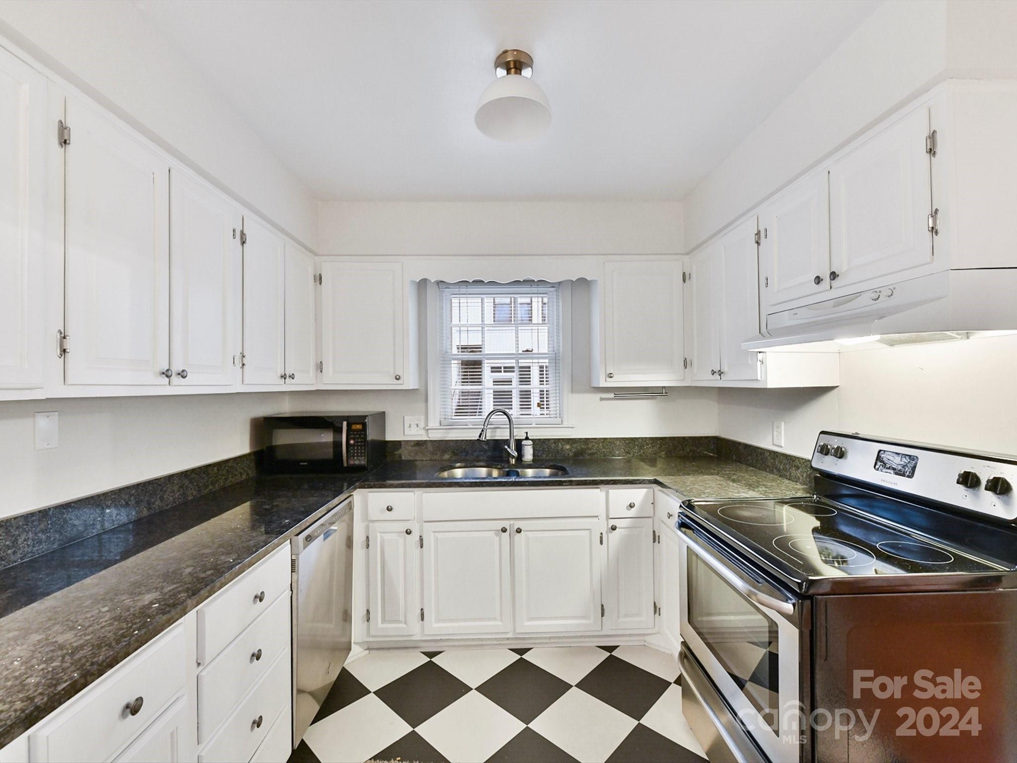 1708 Roxborough Road, Unit E Charlotte, NC 28211 - Photo 14 of 20 a kitchen with granite countertop white cabinets and appliances