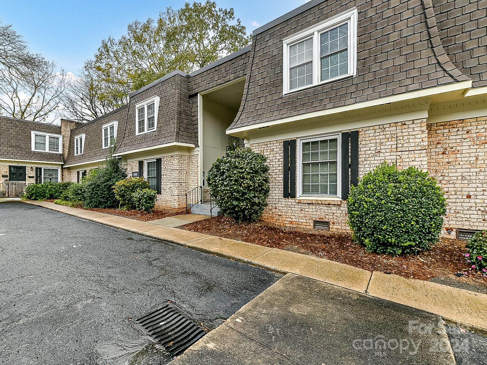 1708 Roxborough Road, Unit E Charlotte, NC 28211 - Photo 2 of 20 a front view of a house with a yard and garage