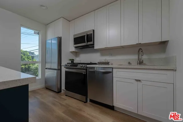 a kitchen with stainless steel appliances granite countertop a refrigerator and a stove top oven