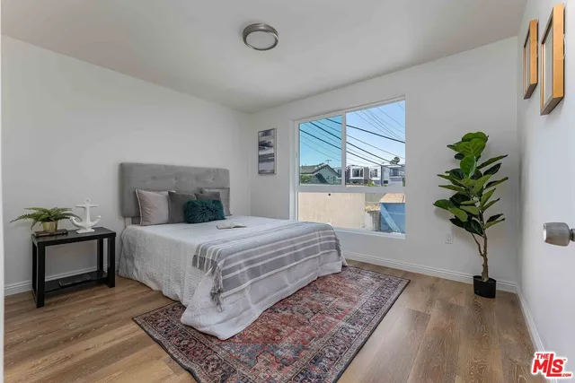 a bedroom with a bed and a potted plant