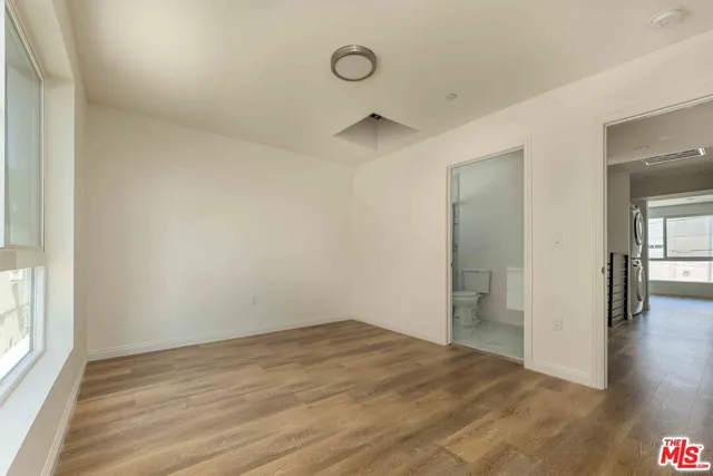 a view of empty room with wooden floor and window