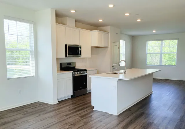 a kitchen with a sink cabinets and wooden floor