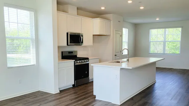a kitchen with kitchen island a sink stainless steel appliances and window