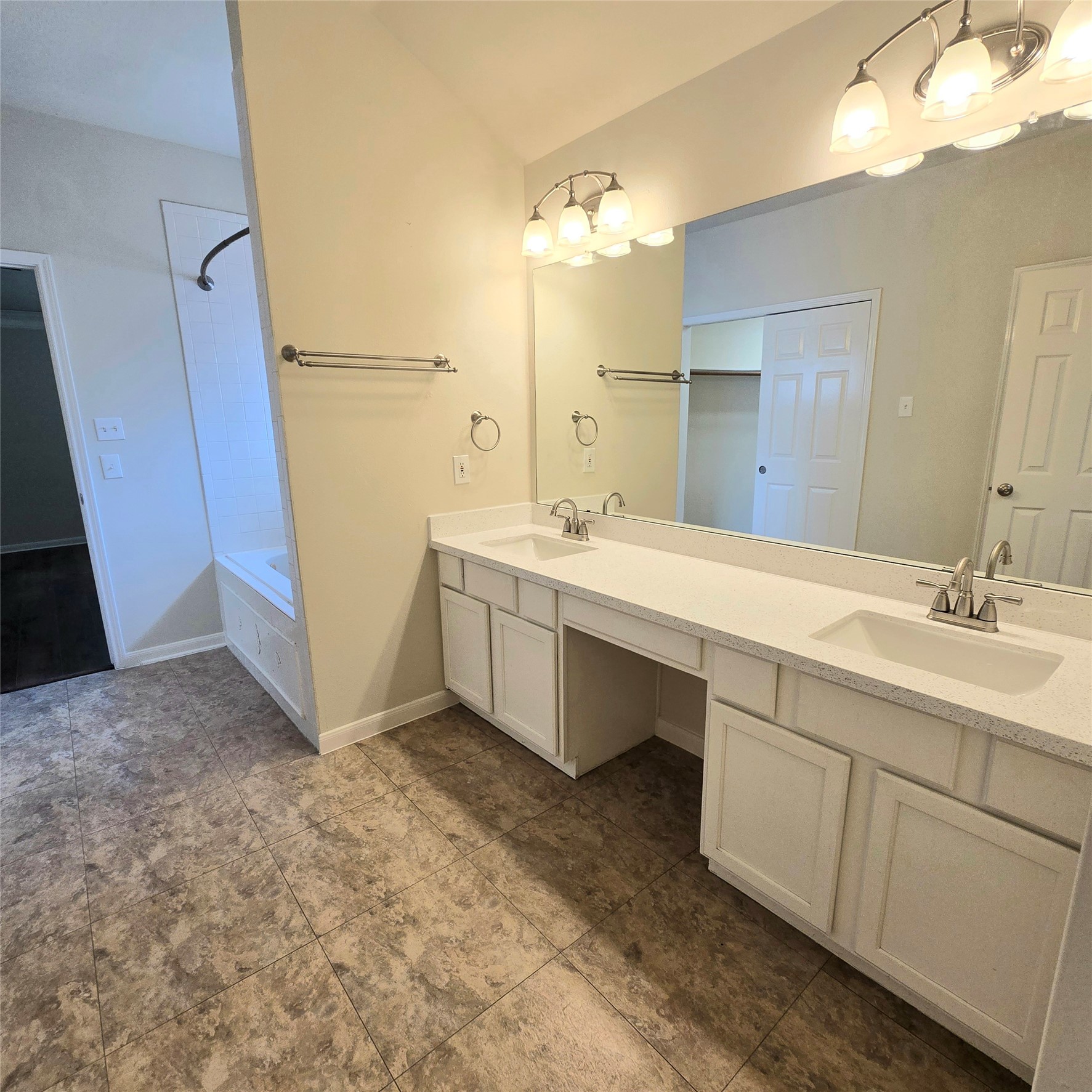 6411 Slate Stone Street Houston, TX 77084 - Photo 12 of 38 Elegant primary bathroom featuring double sinks, a spacious vanity, and modern lighting.