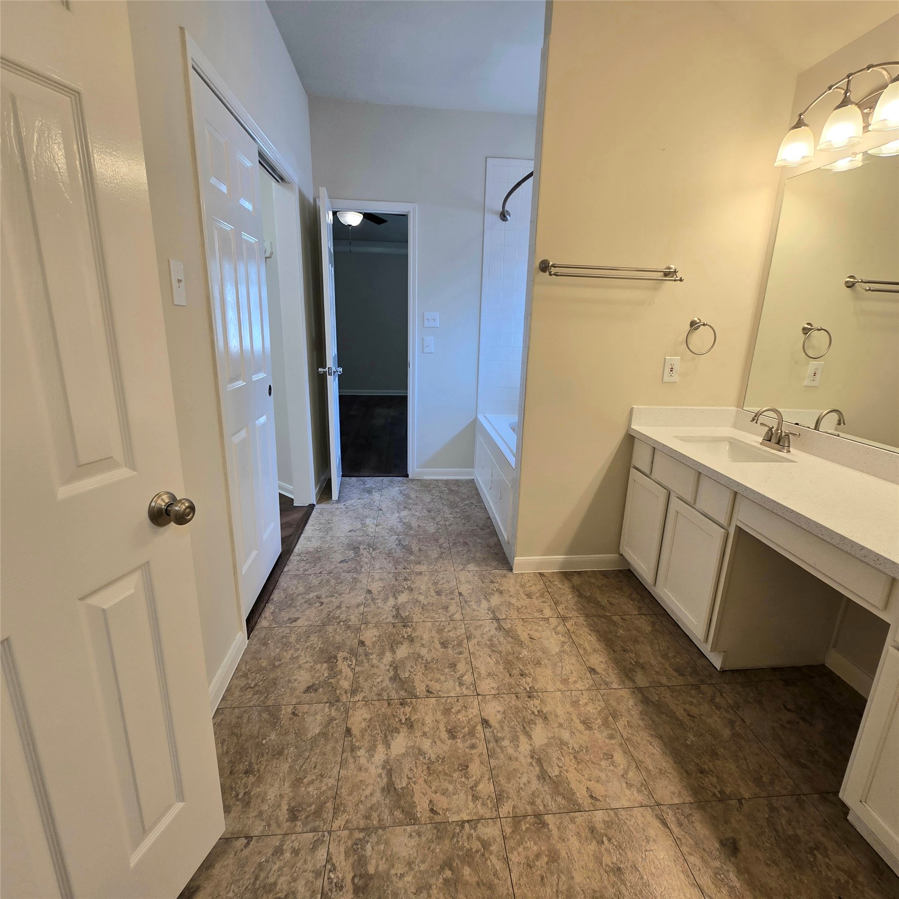 6411 Slate Stone Street Houston, TX 77084 - Photo 13 of 38 Spacious primary bathroom featuring elegant tile flooring, a modern vanity with ample storage, and a relaxing bathtub. Perfect for unwinding after a long day.