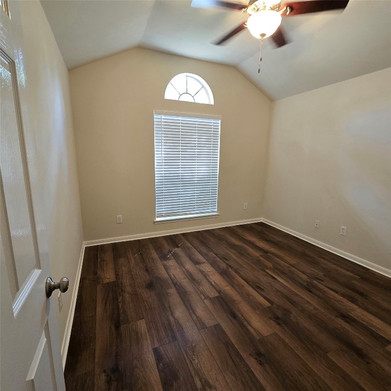 6411 Slate Stone Street Houston, TX 77084 - Photo 14 of 38 Inviting second bedroom with rich wood floors, a large window with blinds, and a stylish ceiling fan with light.